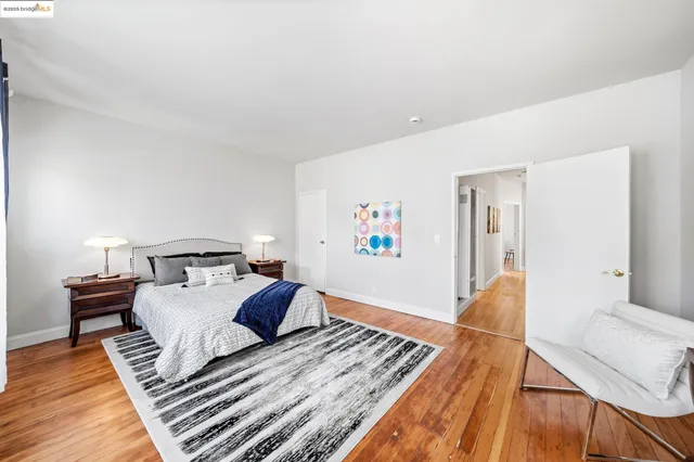 a bedroom with a bed and wooden floor