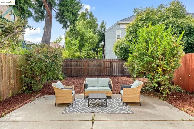 a wooden bench sitting in backside of a house with potted plants and wooden fence