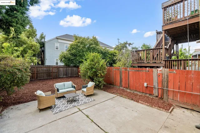 a view of a chairs and table in the back yard of the house
