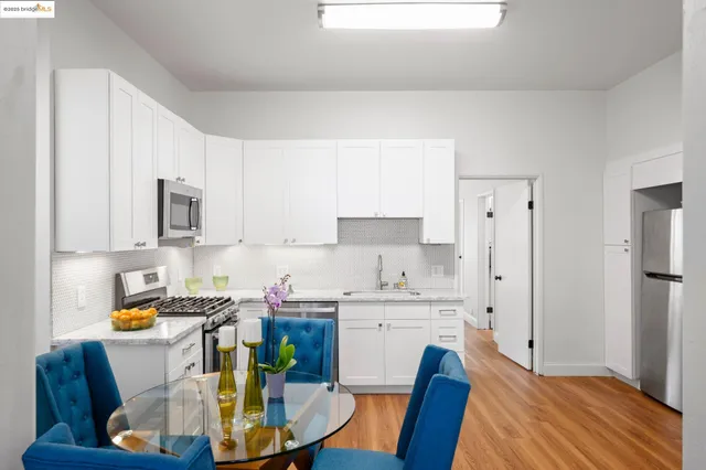a view of kitchen with stainless steel appliances granite countertop a sink a stove a dining table and chairs