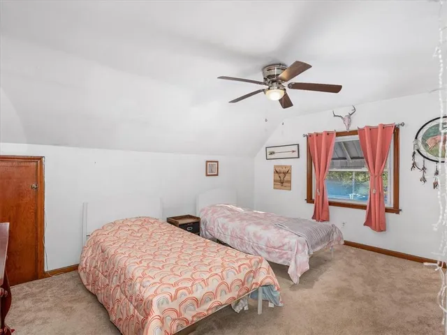 a bedroom with two beds and a ceiling fan