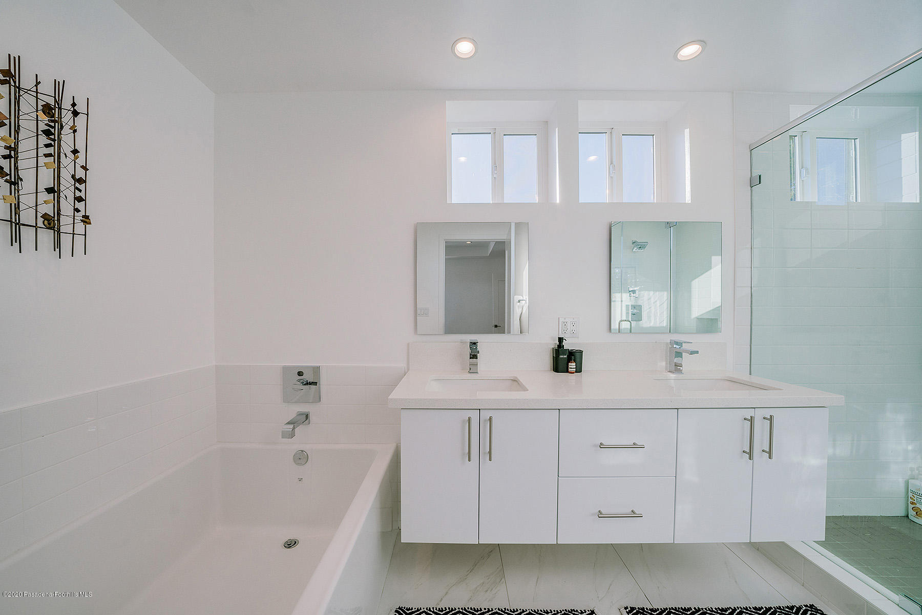 855 Hyperion Avenue Los Angeles, CA 90029 - Photo 14 of 35 a bathroom with a double vanity sink a mirror and a bathtub