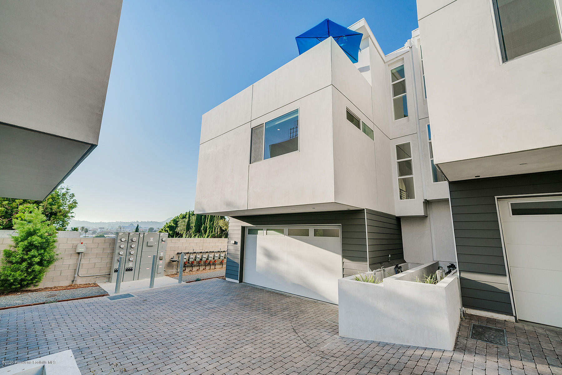 855 Hyperion Avenue Los Angeles, CA 90029 - Photo 32 of 35 a view of a white house with large windows and a small yard