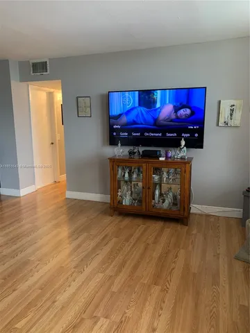 a view of a dining room with furniture a rug and wooden floor
