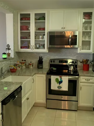 a kitchen with stainless steel appliances granite countertop a refrigerator and a stove