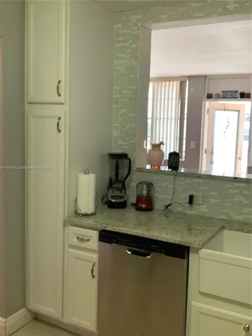 a bathroom with a granite countertop sink a toilet and a window