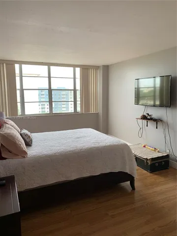 a bedroom with a bed and a flat screen tv