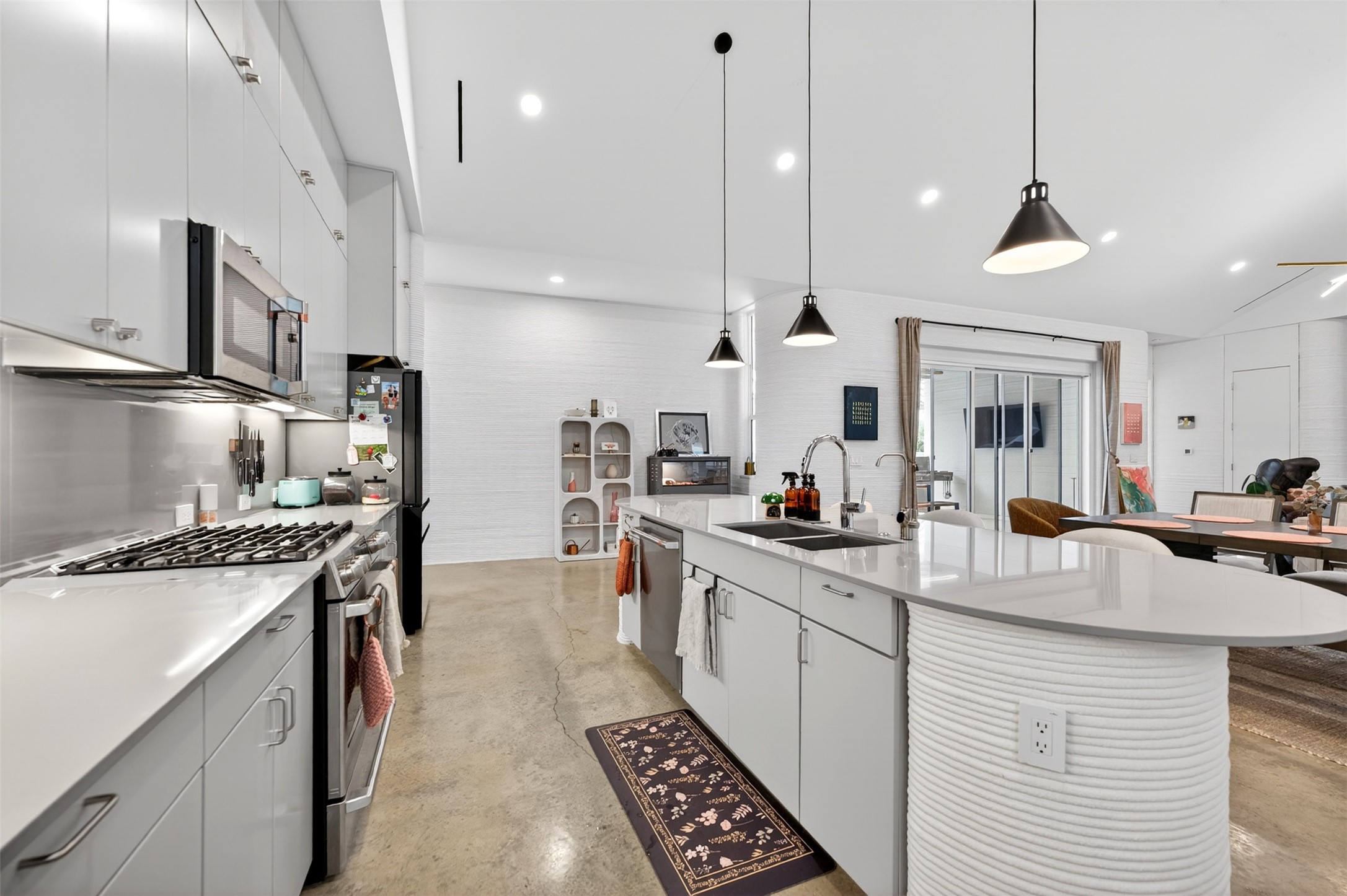308 Painted Sunset Drive Georgetown, TX 78628 - Photo 10 of 26 Spacious kitchen featuring white cabinetry, stainless steel appliances, a gas range, and a large central island with an integrated sink and pendant lighting