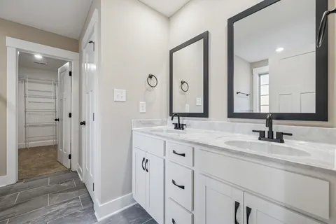 a bathroom with double vanity sinks and a mirror