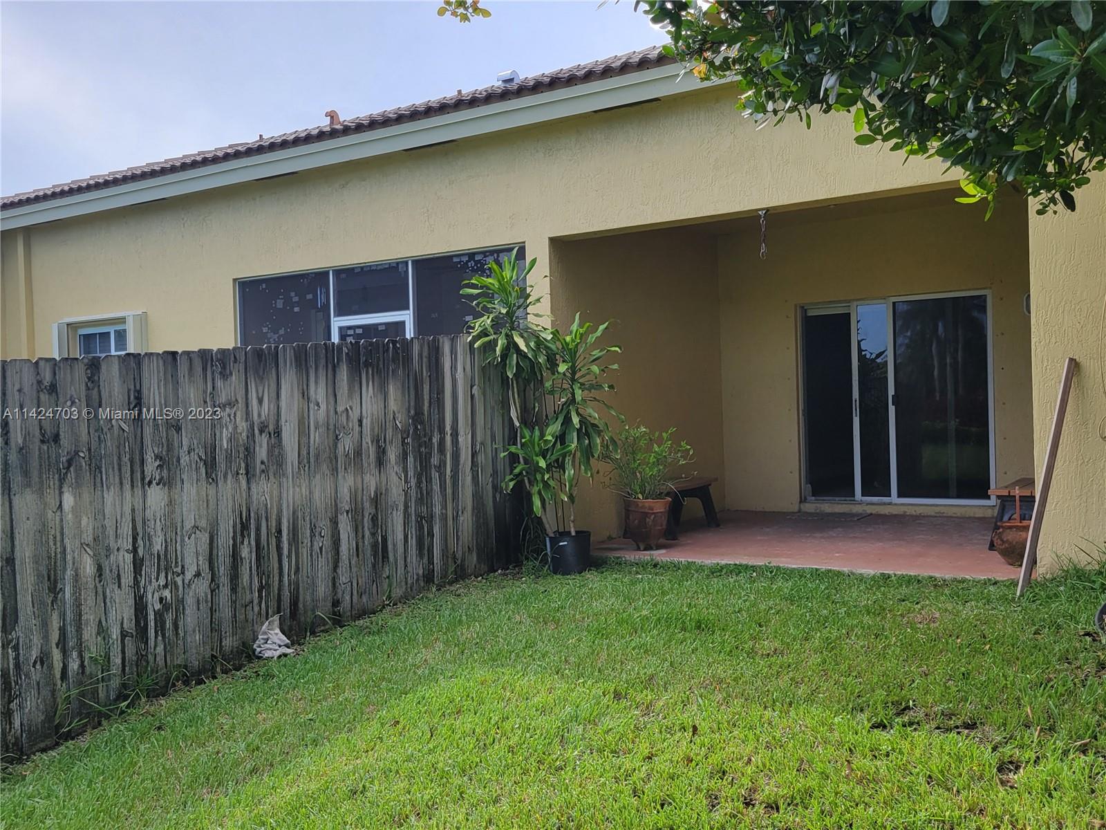 3390 Northeast 11th Drive, Unit 3390 Homestead, FL 33033 - Photo 17 of 20 a backyard of a house with table and chairs