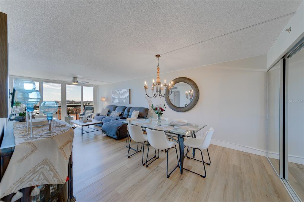 255 Dolphin Point, Unit 802 Clearwater Beach, FL 33767 - Photo 11 of 41 a view of a dining room with furniture a chandelier and wooden floor