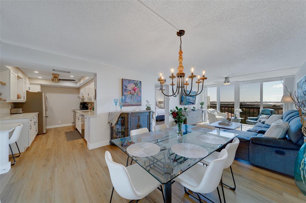 255 Dolphin Point, Unit 802 Clearwater Beach, FL 33767 - Photo 12 of 41 a view of a dining room with furniture wooden floor and chandelier