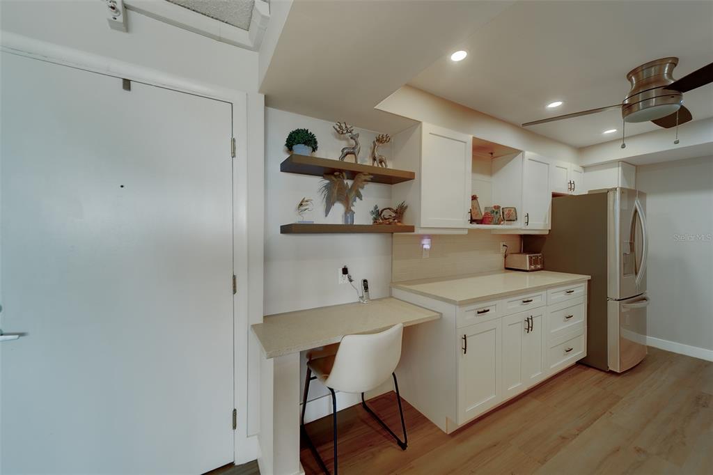 255 Dolphin Point, Unit 802 Clearwater Beach, FL 33767 - Photo 16 of 41 a kitchen with a sink a refrigerator and chairs