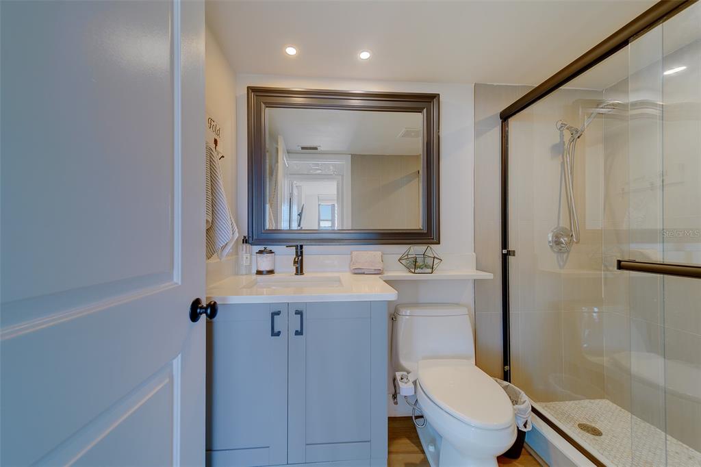 255 Dolphin Point, Unit 802 Clearwater Beach, FL 33767 - Photo 19 of 41 a bathroom with a toilet a sink a tub and mirror