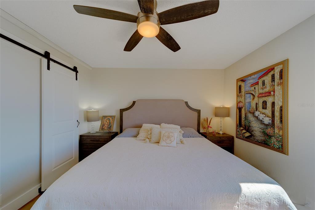 255 Dolphin Point, Unit 802 Clearwater Beach, FL 33767 - Photo 25 of 41 a bedroom with a bed and painting on the wall