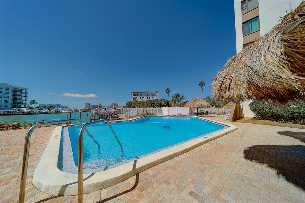 255 Dolphin Point, Unit 802 Clearwater Beach, FL 33767 - Photo 29 of 41 a view of a swimming pool with a lounge chair