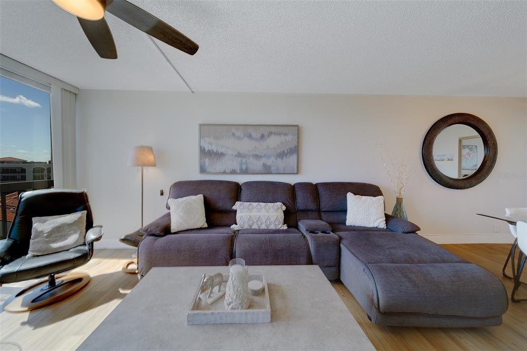 255 Dolphin Point, Unit 802 Clearwater Beach, FL 33767 - Photo 7 of 41 a living room with furniture and a mirror