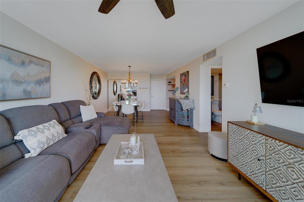 255 Dolphin Point, Unit 802 Clearwater Beach, FL 33767 - Photo 8 of 41 a living room with furniture and a flat screen tv
