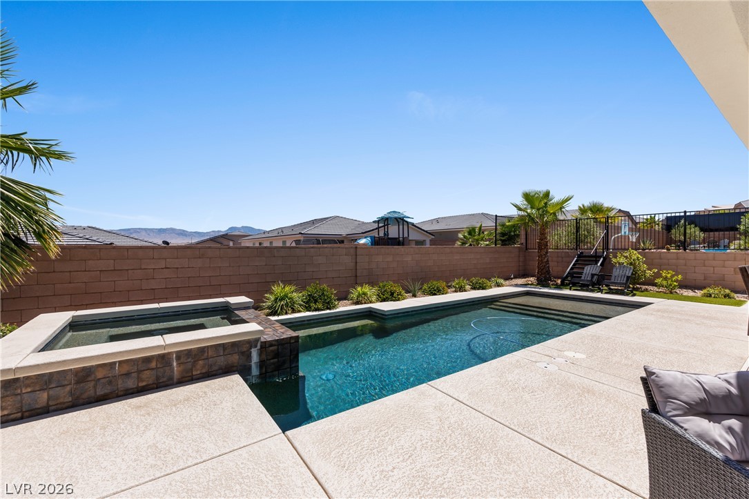 1436 Manassas Ridge Mesquite, NV 89027 - Photo 49 of 77 An inviting backyard oasis offers a sparkling pool and spa, perfect for relaxation and entertaining.