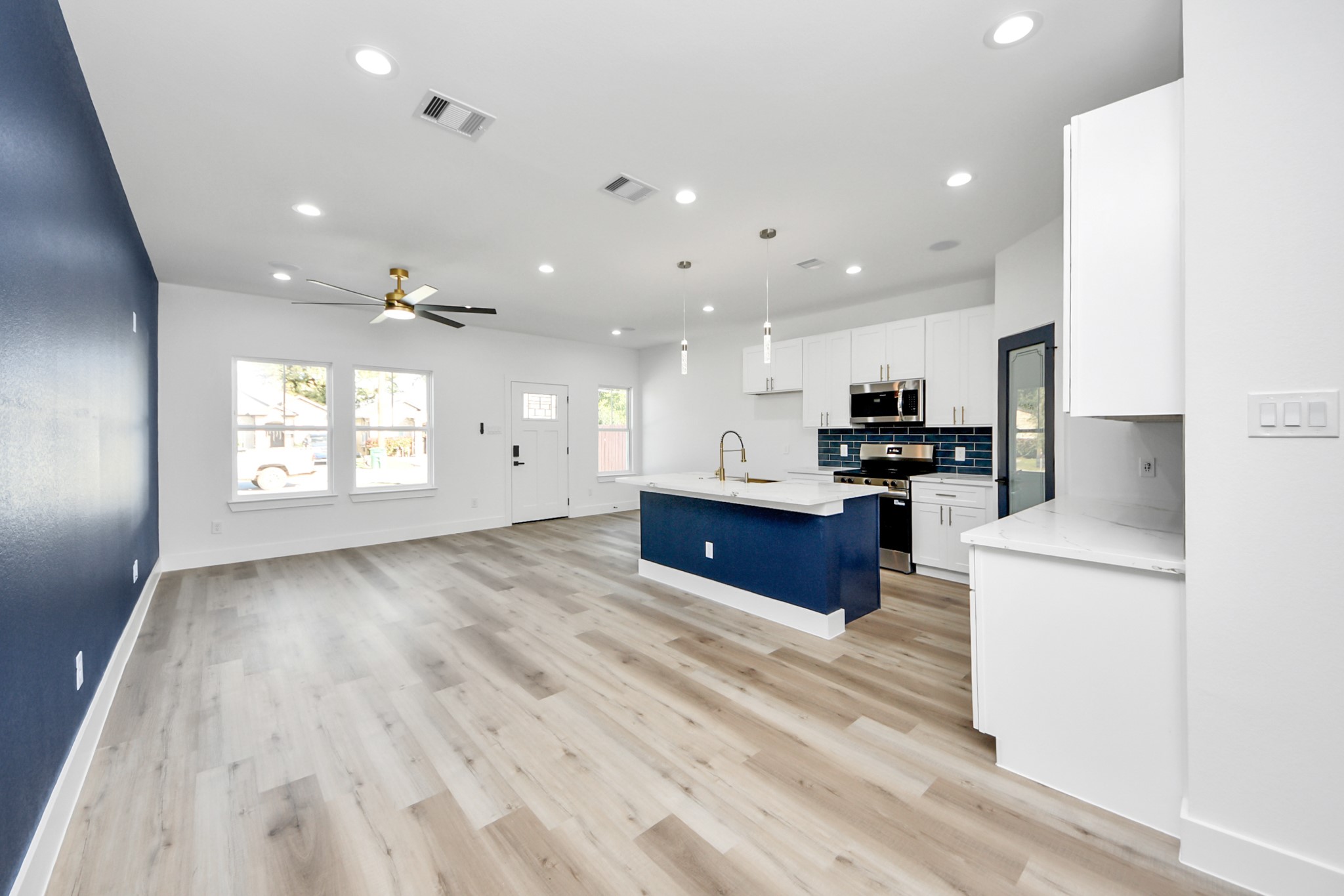 4606 Mallow Street Houston, TX 77051 - Photo 13 of 31 Living room features beautiful flooring, a ceiling fan, accent wall, and recessed lighting.