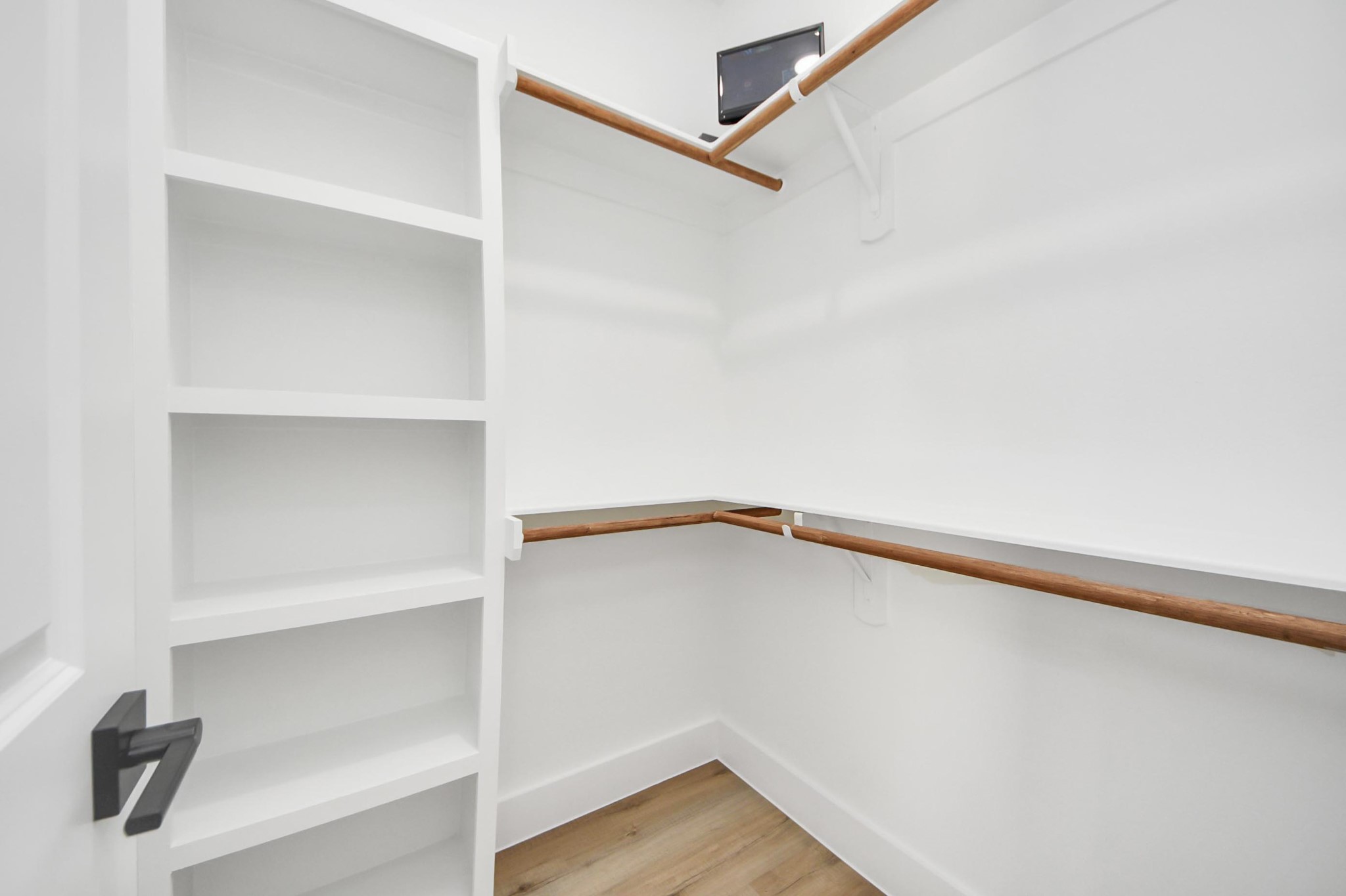 4606 Mallow Street Houston, TX 77051 - Photo 25 of 31 This is a spacious walk-in closet with white walls and light flooring. It features multiple wooden hanging rods and built-in shelves for ample storage.