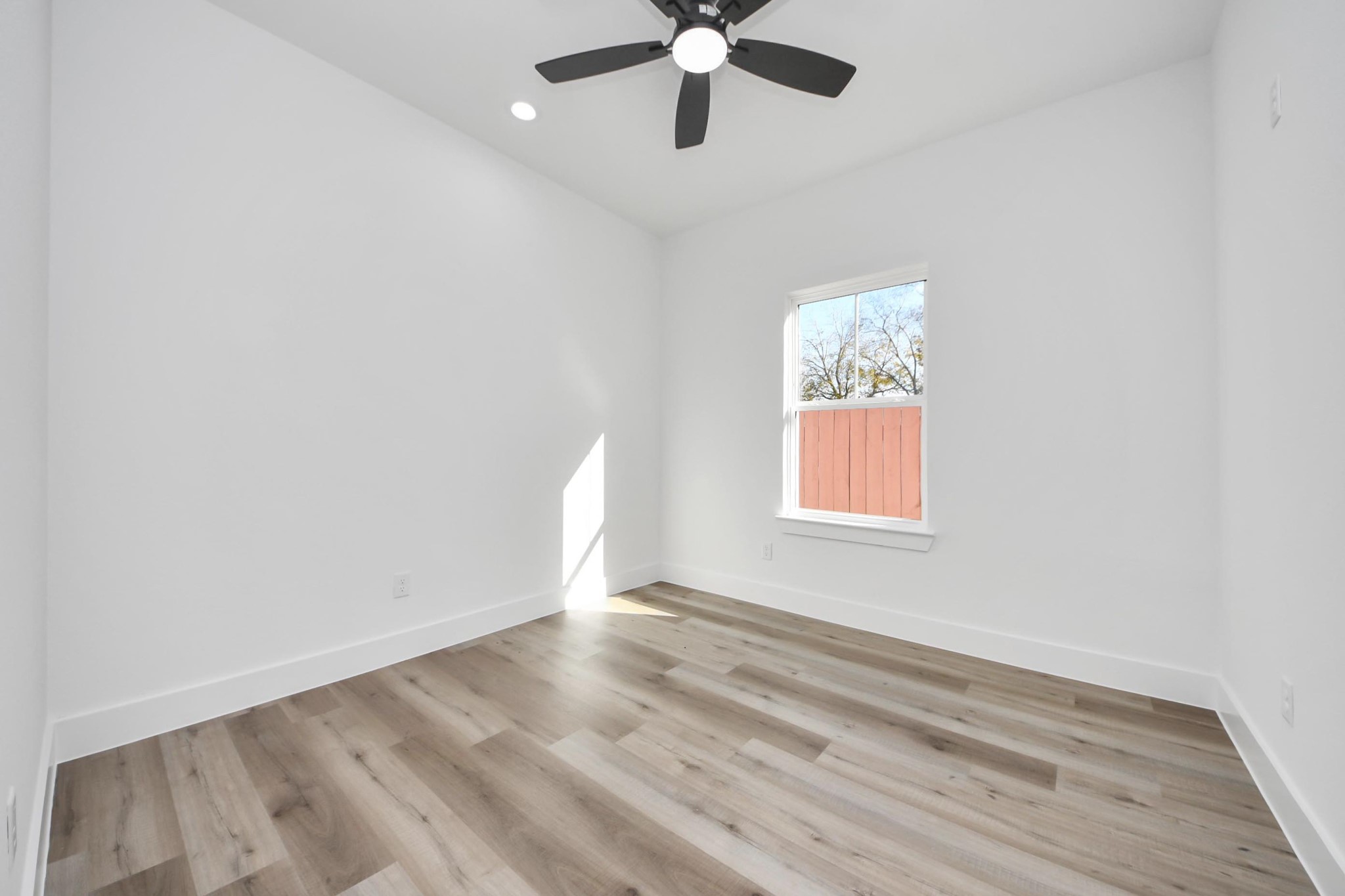 4606 Mallow Street Houston, TX 77051 - Photo 26 of 31 an empty room with wooden floor chandelier fan and windows