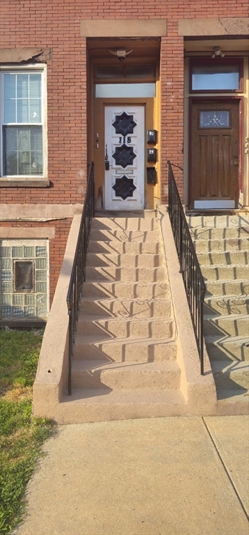 118 Winthrop Street, Unit 2 Boston, MA 02119 - Photo 1 of 7 a front view of a house with a yard