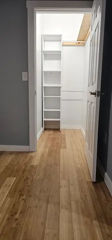 a view of a room with wooden floor and door
