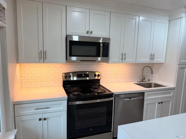 a kitchen with a sink stove and microwave