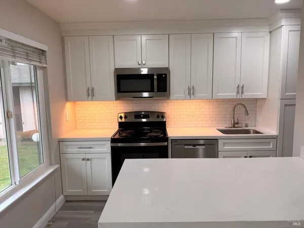 a kitchen with stainless steel appliances a stove a sink a microwave and cabinets