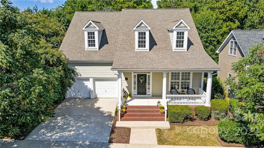 a front view of a house with a yard and trees