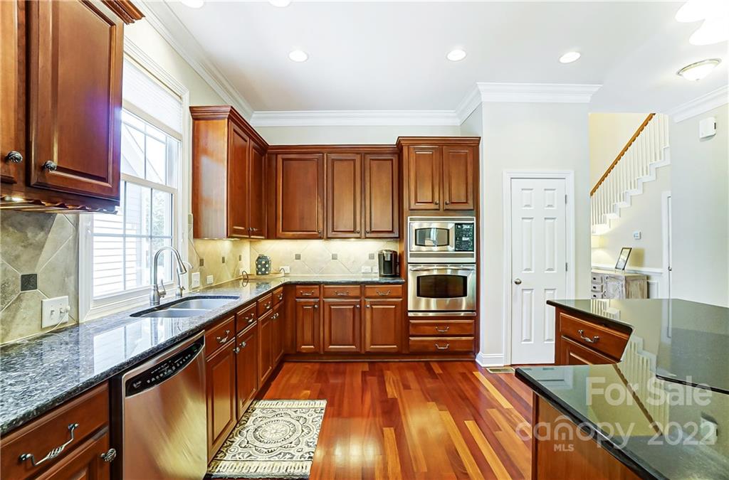146 Mills Lane Fort Mill, SC 29708 - Photo 17 of 48 a kitchen with stainless steel appliances granite countertop wooden cabinets a sink dishwasher a stove and a refrigerator with wooden floor