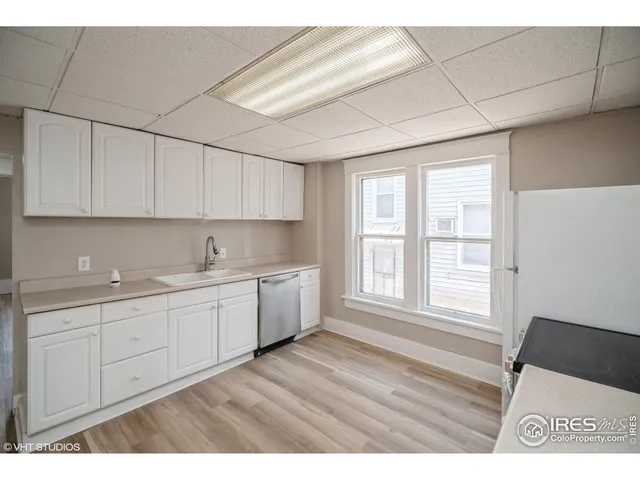 a open kitchen with cabinets appliances a sink and a window