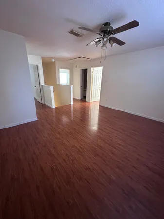 a view of a livingroom with a ceiling fan and wooden floor