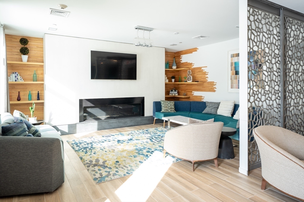 180 Telford Street, Unit 605 Boston, MA 02135 - Photo 16 of 24 a living room with furniture a flat screen tv and a fireplace