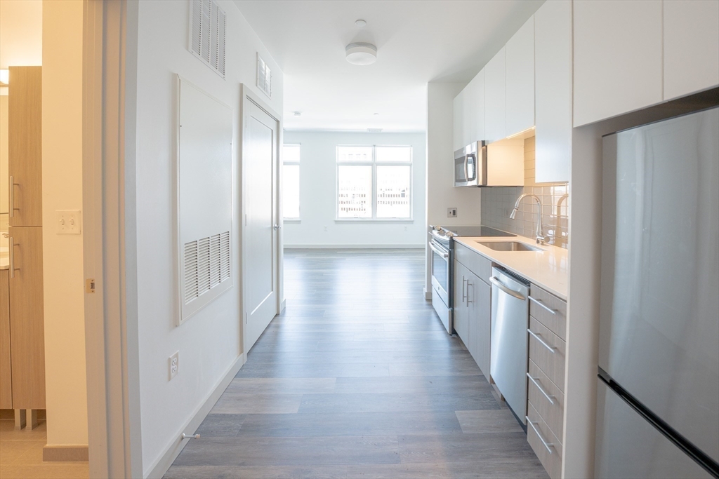 180 Telford Street, Unit 605 Boston, MA 02135 - Photo 5 of 24 a kitchen with stainless steel appliances a refrigerator and a stove
