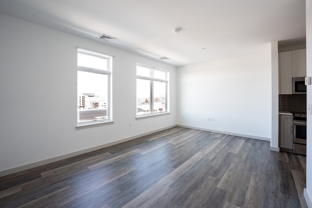 180 Telford Street, Unit 605 Boston, MA 02135 - Photo 8 of 24 an empty room with wooden floor and window
