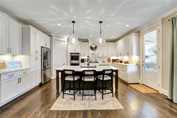 a kitchen with granite countertop white cabinets and white stainless steel appliances