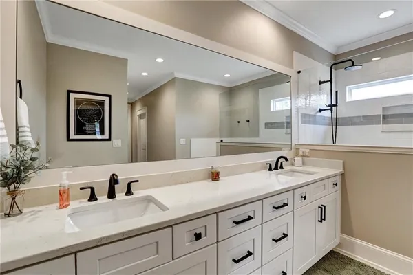 a bathroom with a double vanity sink mirror and shower