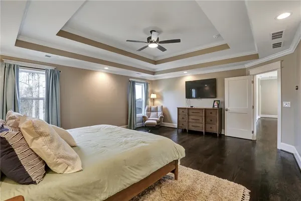 a bedroom with a bed and large windows