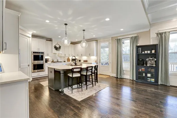 a kitchen with stainless steel appliances kitchen island granite countertop a table chairs and a refrigerator