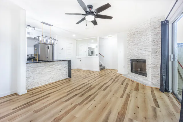 an empty room with chandelier fan and windows
