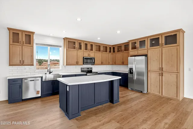 a kitchen with a sink stove top oven and refrigerator