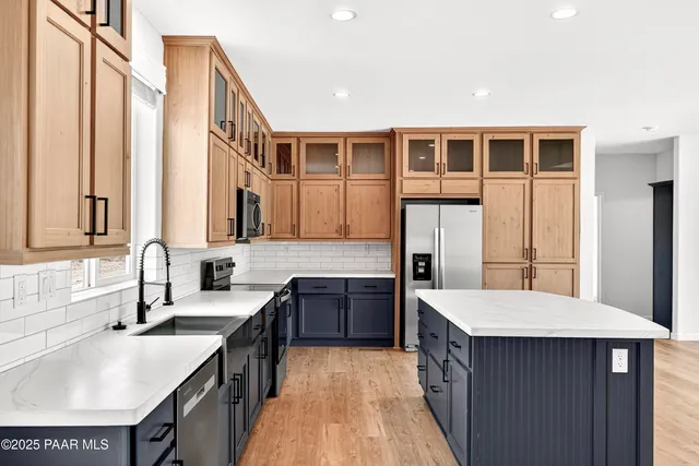 a large kitchen with kitchen island granite countertop a stove a sink and dishwasher