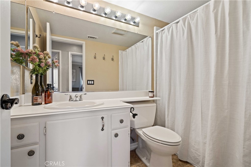 25510 Chisom Lane Stevenson Ranch, CA 91381 - Photo 24 of 53 a bathroom with a sink a toilet a mirror and shower curtain