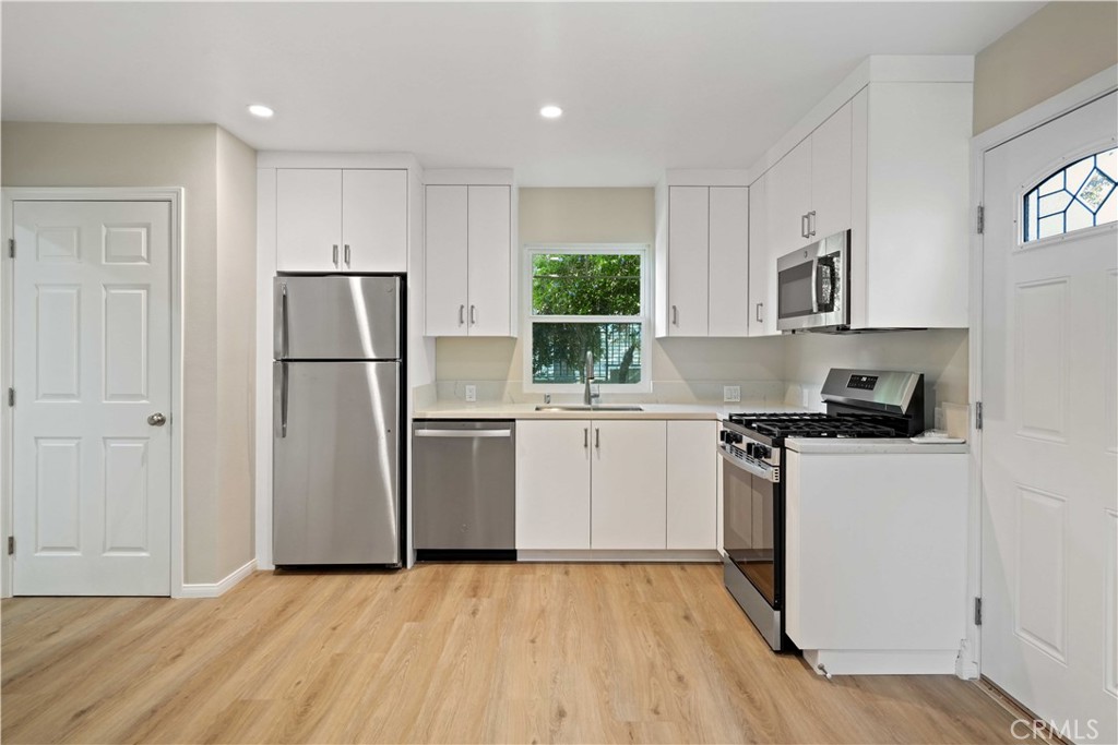 25510 Chisom Lane Stevenson Ranch, CA 91381 - Photo 36 of 53 a kitchen with a refrigerator a stove a microwave and a window