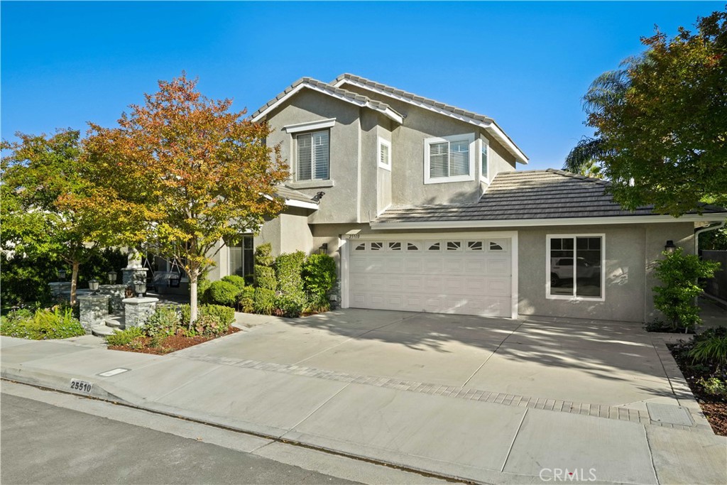 25510 Chisom Lane Stevenson Ranch, CA 91381 - Photo 6 of 53 a front view of a house with a garden and trees