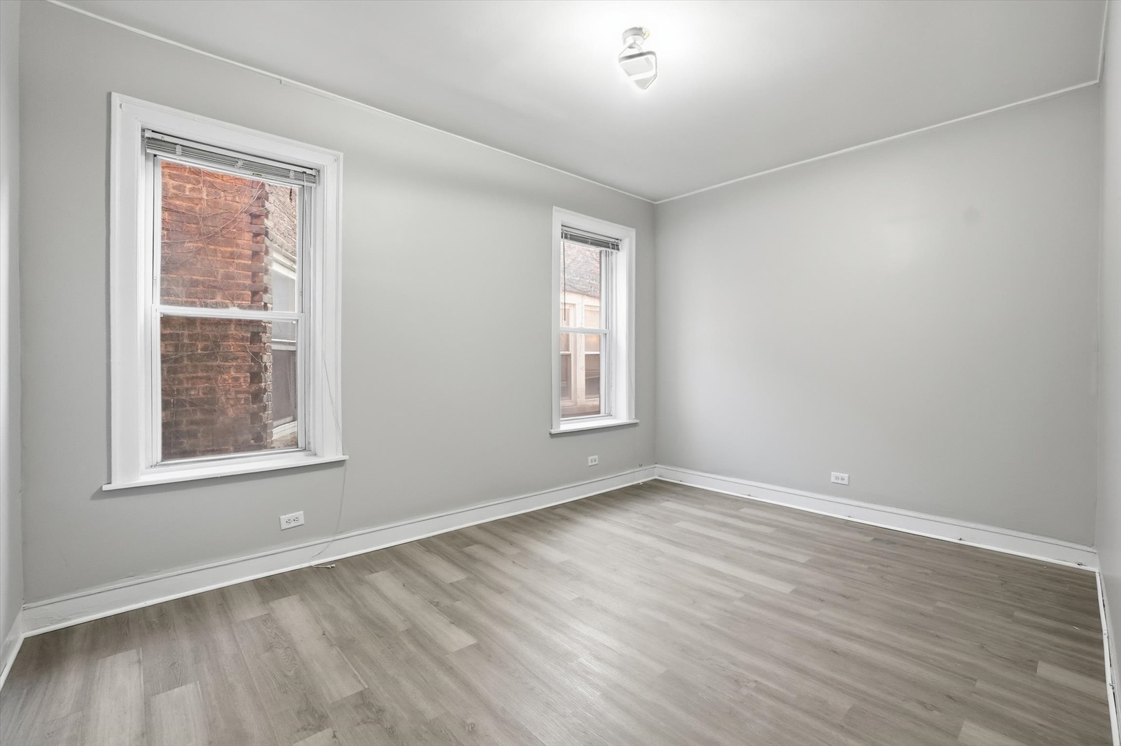 8434 South Drexel Avenue Chicago, IL 60619 - Photo 11 of 19 an empty room with wooden floor and windows