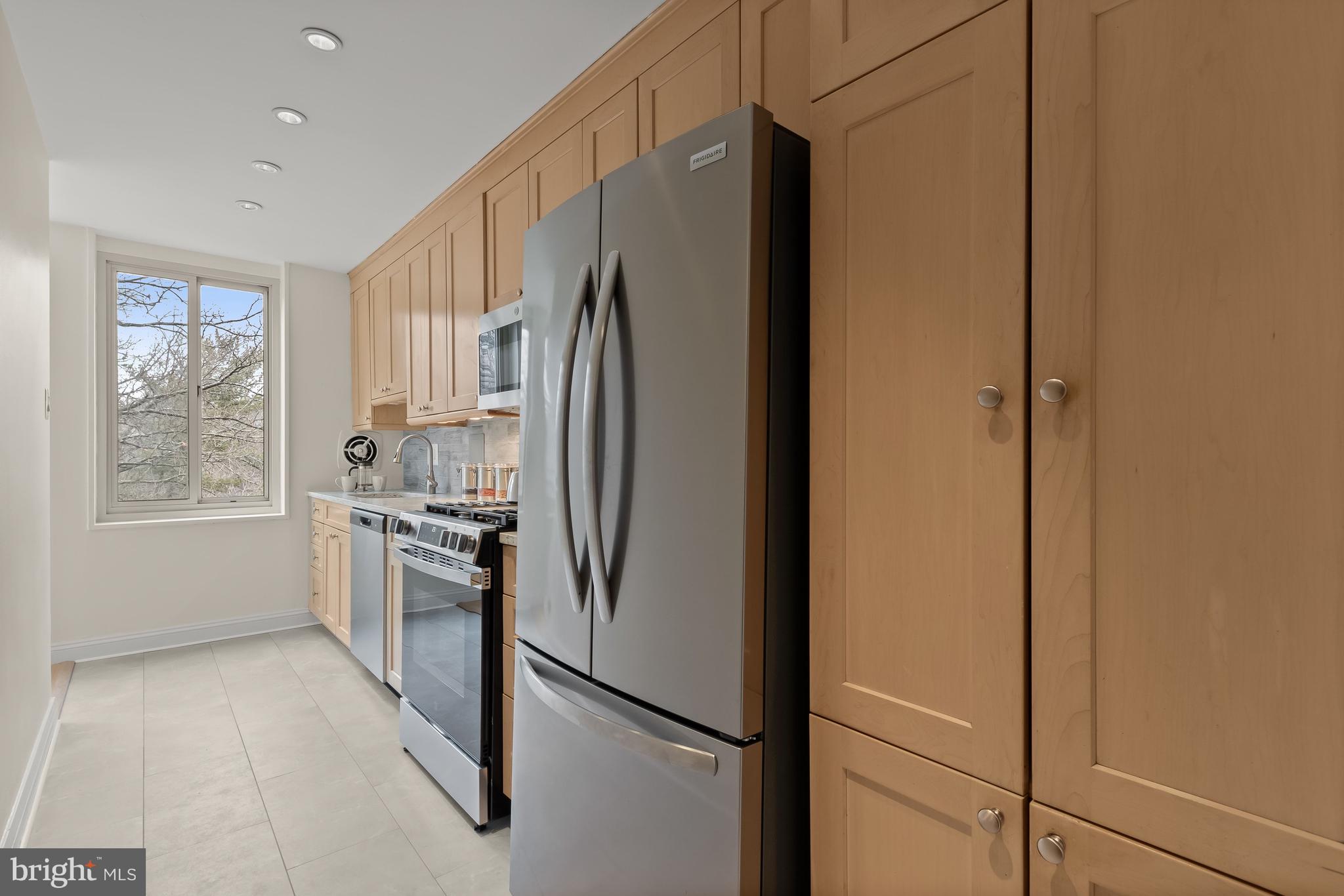 4000 Tunlaw Road Northwest, Unit 1007 Washington, DC 20007 - Photo 13 of 50 a kitchen with stainless steel appliances a refrigerator sink and cabinets