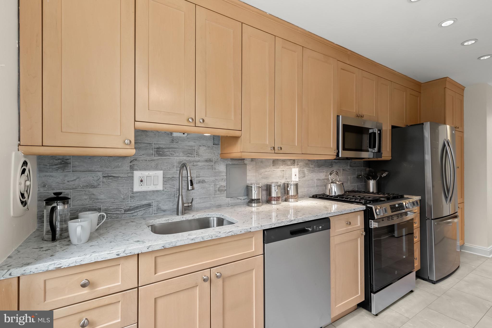 4000 Tunlaw Road Northwest, Unit 1007 Washington, DC 20007 - Photo 15 of 50 a kitchen with appliances a sink and cabinets